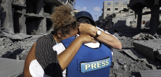 Zahraniční novinářka objímá svého palestinského asistenta, který právě zjistil, že izraelské útoky zničily jeho dům.