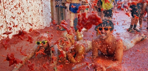 Nadšení účastníci rajčatové bitvy se do boje vrhají po hlavě.