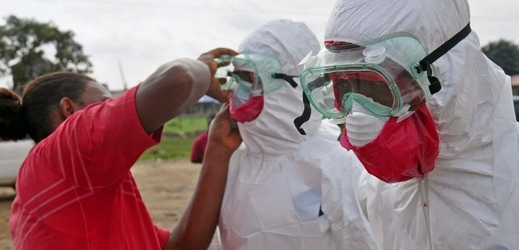 Zdravotníci v Libérii si nasazují ochranné obleky. 