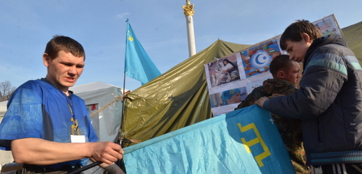 Muži vyvěšují vlajku nad stanem organizace krymských Tatarů při protestech proti anexi Krymu.
