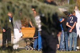 Příbuzní truchlí u rakve Mohameda Meraha na jeho pohřbu v blízkosti Toulouse v jižní Francii.