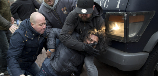 Policisté v civilu zatýkají jednoho z demonstrantů v Amsterdamu.